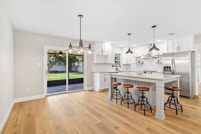 5162 Tellson Pl, Orlando, FL 32812 - kitchen with stainless steel fridge, backsplash, wall chimney range hood, and visible vents