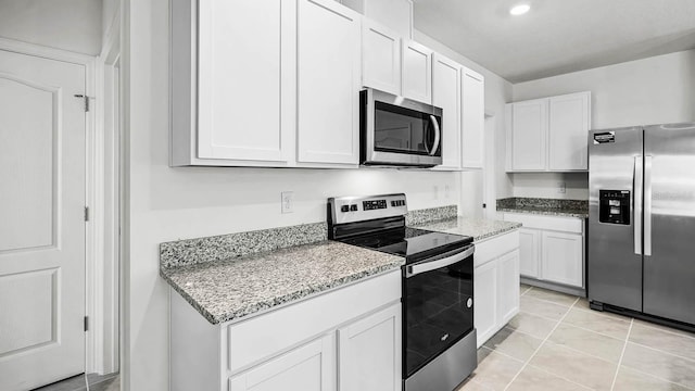 kitchen featuring light stone countertops, appliances with stainless steel finishes, white cabinetry, recessed lighting, and light tile patterned floors