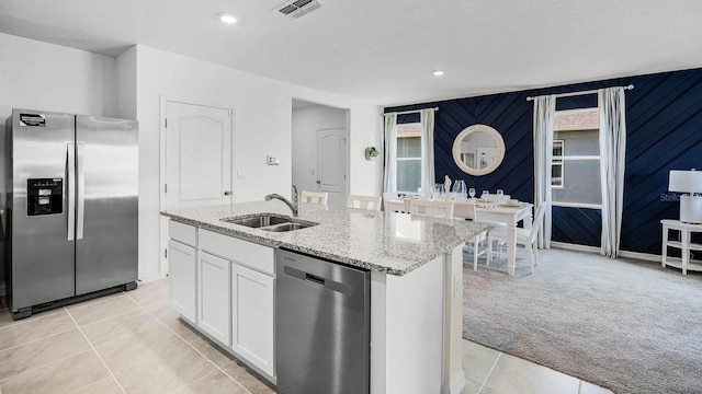 kitchen with visible vents, light carpet, white cabinets, a sink, and appliances with stainless steel finishes