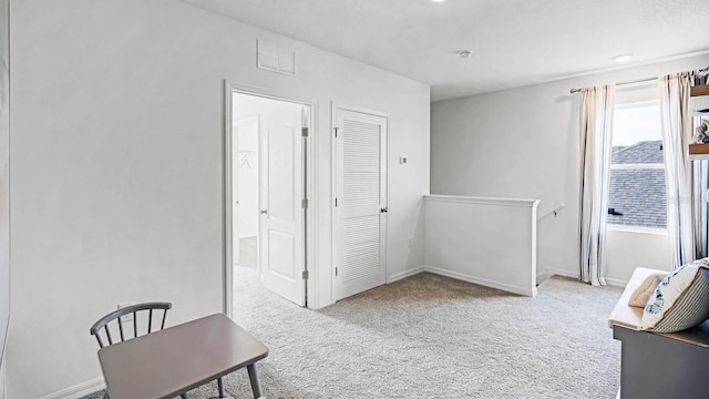 interior space featuring baseboards, visible vents, and carpet