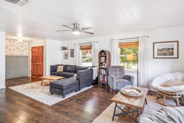 8619 Veridian Dr, Orlando, FL 32810 - living room featuring dark wood-style flooring, a ceiling fan, visible vents, and wainscoting