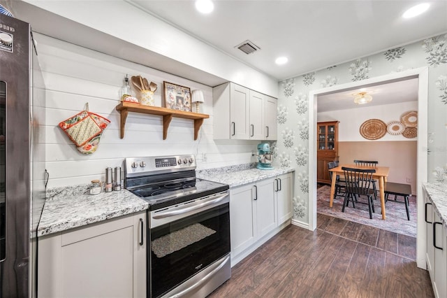 8619 Veridian Dr, Orlando, FL 32810 - kitchen with dark wood-type flooring, white cabinets, stainless steel range with electric cooktop, and wallpapered walls