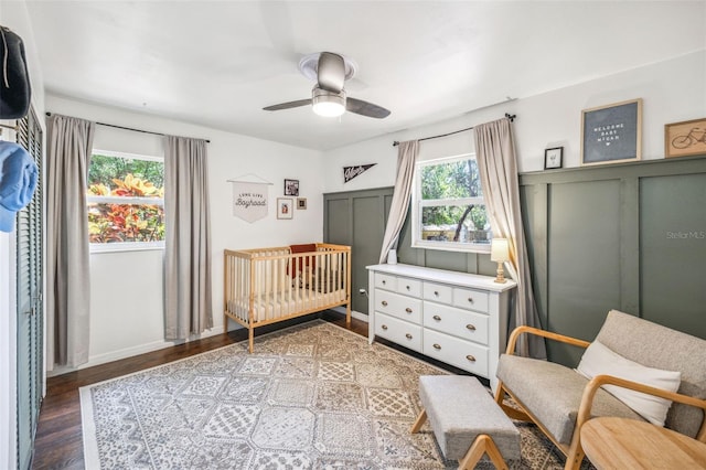 8619 Veridian Dr, Orlando, FL 32810 - bedroom featuring a nursery area, baseboards, a ceiling fan, and wood finished floors