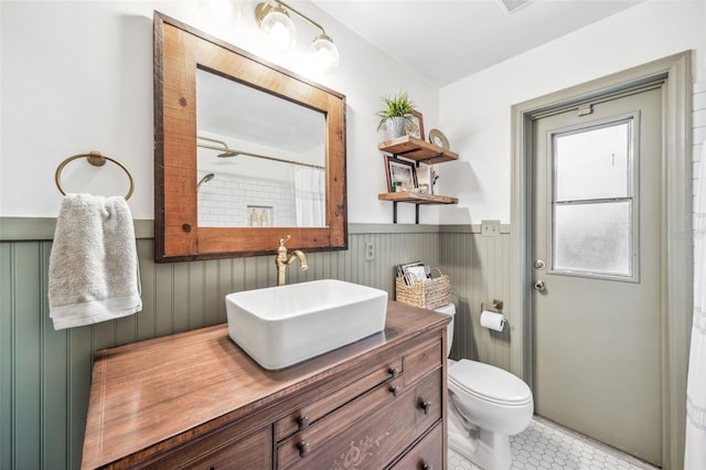 8619 Veridian Dr, Orlando, FL 32810 - bathroom featuring vanity, toilet, tile patterned flooring, and a wainscoted wall