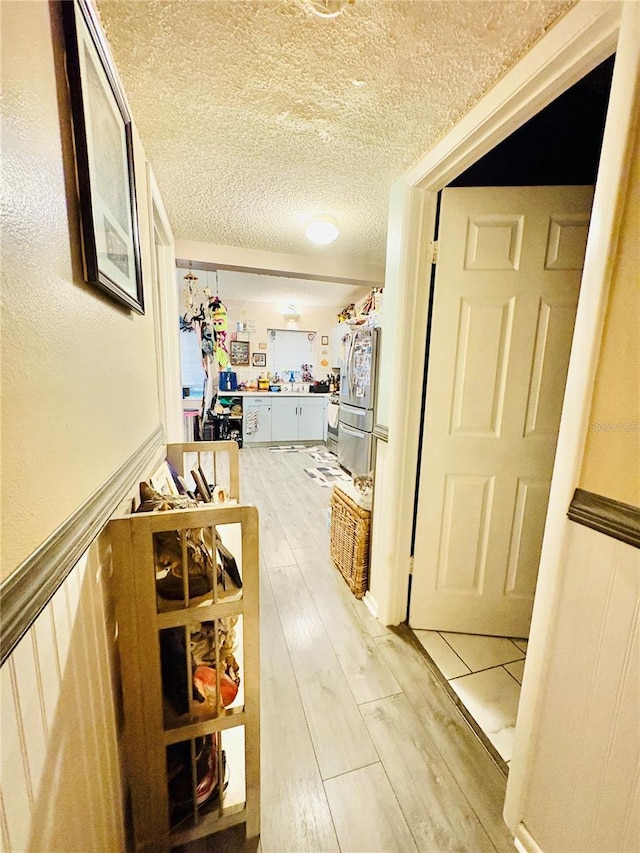 116 Lincoln Ave Unit 116-118, Cape Canaveral, FL 32920 - hall with light wood-style flooring and a textured ceiling
