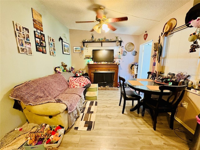 116 Lincoln Ave Unit 116-118, Cape Canaveral, FL 32920 - living room featuring a textured ceiling, light wood finished floors, a ceiling fan, and a fireplace