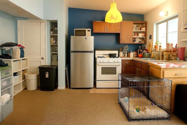 116 Lincoln Ave Unit 116-118, Cape Canaveral, FL 32920 - kitchen with white appliances, open shelves, brown cabinetry, hanging light fixtures, and light carpet