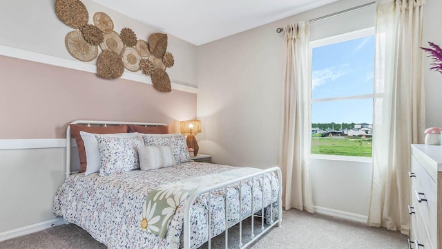 carpeted bedroom with baseboards and multiple windows