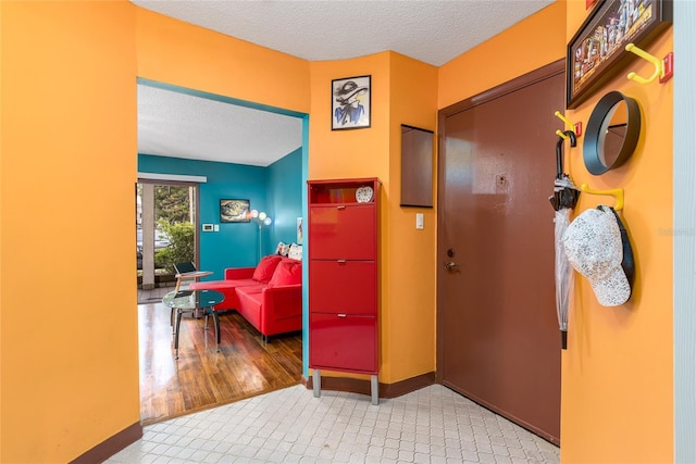 hallway with baseboards and a textured ceiling