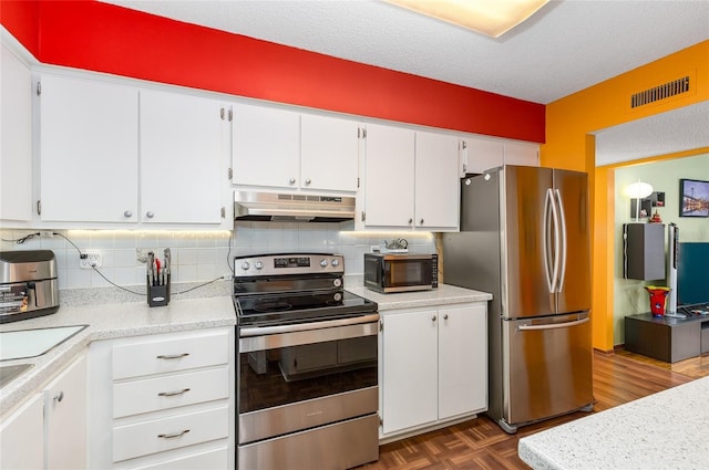 kitchen with visible vents, light countertops, white cabinets, under cabinet range hood, and stainless steel appliances