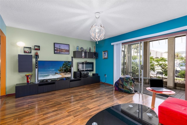 living room featuring a textured ceiling, wood finished floors, and a notable chandelier