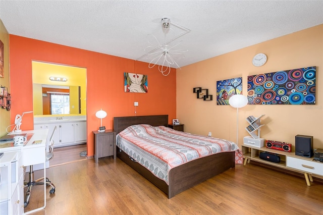 bedroom with an inviting chandelier and wood finished floors