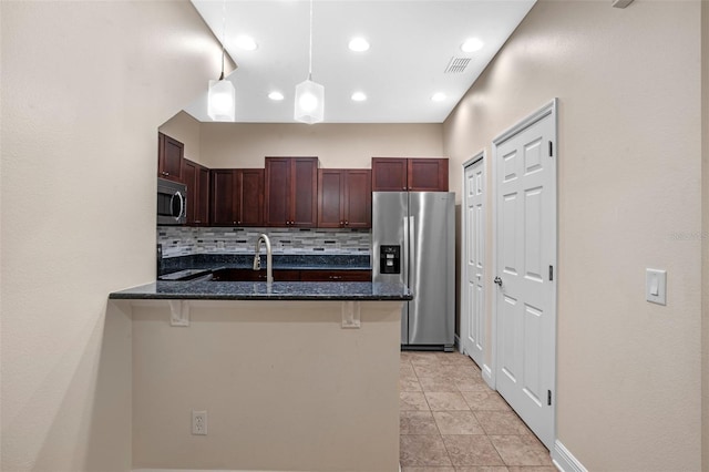 8031 Enchantment Dr Unit Ge, Windermere, FL 34786 - kitchen with a peninsula, stainless steel appliances, tasteful backsplash, dark stone countertops, and visible vents
