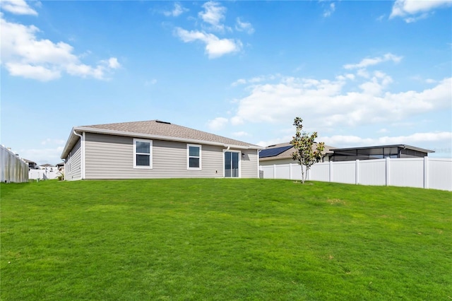 back of property with a yard and fence