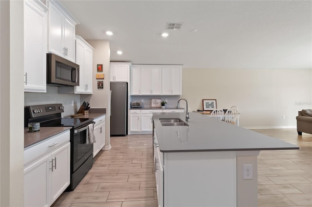5347 Travertine St, Mount Dora, FL 32757 - kitchen with stainless steel appliances, a sink, an island with sink, open floor plan, and white cabinets
