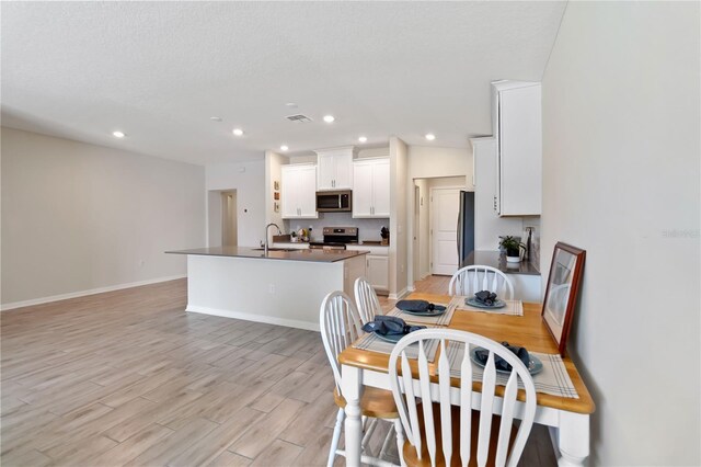 5347 Travertine St, Mount Dora, FL 32757 - dining area with light wood-type flooring, recessed lighting, and baseboards