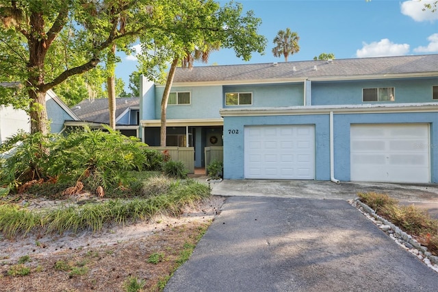 view of front of home with an attached garage, stucco siding, and driveway