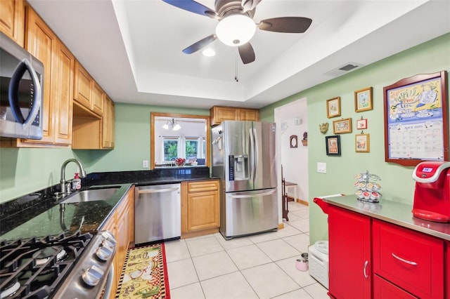 kitchen with visible vents, a ceiling fan, a raised ceiling, a sink, and appliances with stainless steel finishes