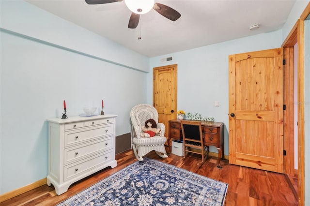 sitting room with visible vents, a ceiling fan, and wood finished floors