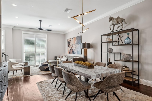 dining room with crown molding, recessed lighting, and dark wood finished floors