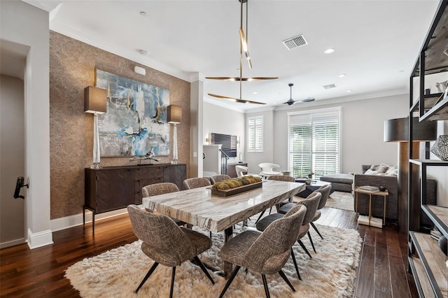 dining room featuring wood-type flooring, ceiling fan, visible vents, and crown molding