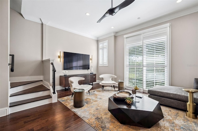 living area with ceiling fan, wood finished floors, stairway, ornamental molding, and recessed lighting