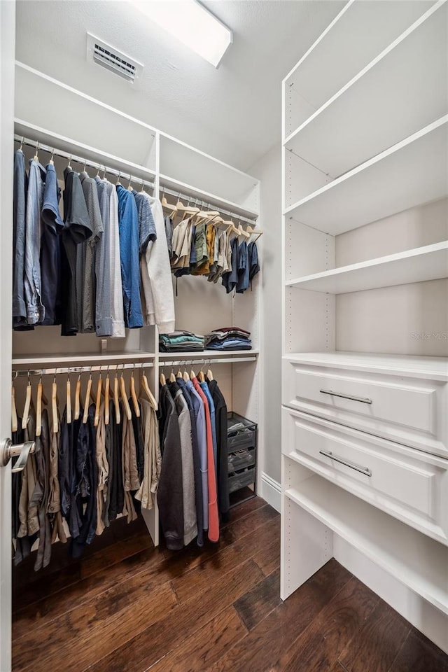 walk in closet with visible vents and dark wood finished floors