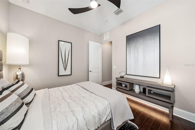 bedroom featuring visible vents, baseboards, and dark wood-style floors