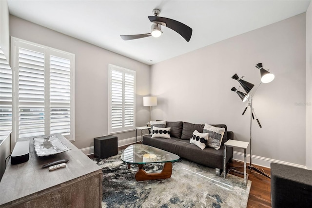 living room featuring baseboards, a ceiling fan, and wood finished floors