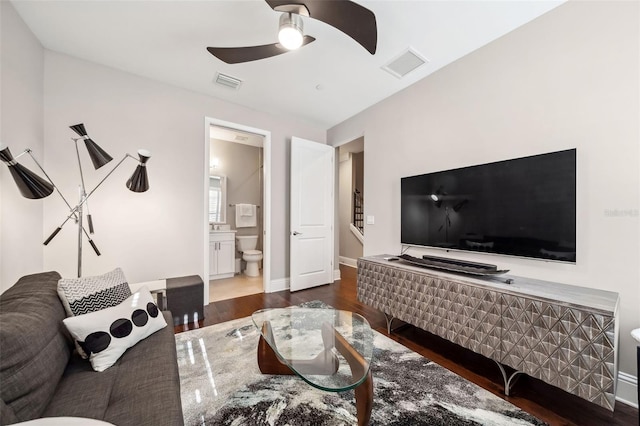 living area with ceiling fan, visible vents, and wood finished floors