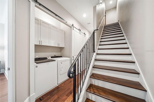 stairs featuring separate washer and dryer, a barn door, wood finished floors, and recessed lighting