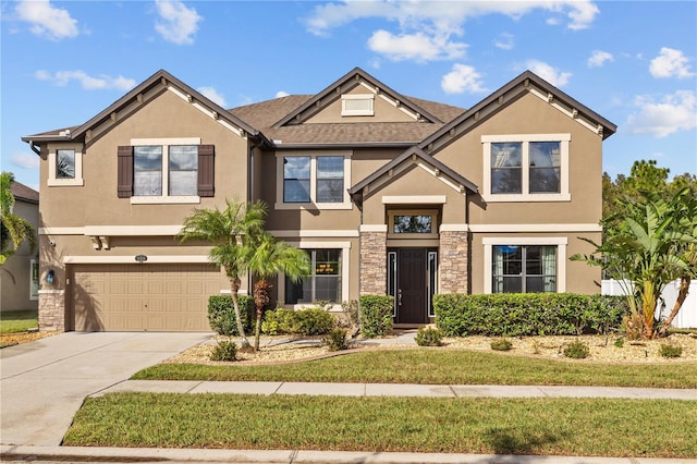 craftsman inspired home with driveway, a front yard, a garage, stone siding, and stucco siding