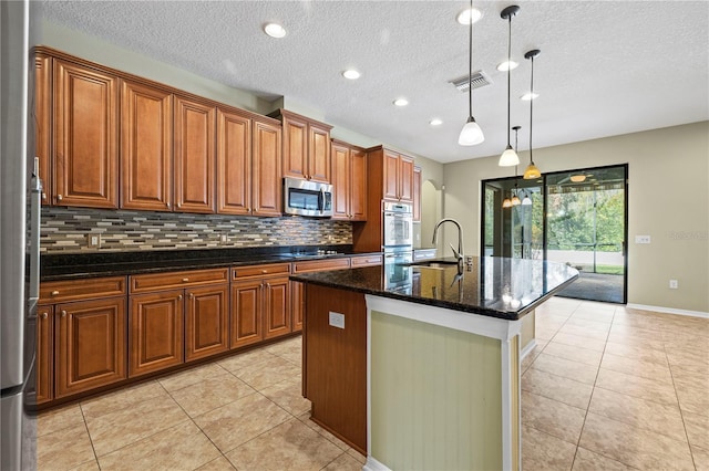 kitchen featuring visible vents, black electric cooktop, a sink, stainless steel microwave, and light tile patterned flooring
