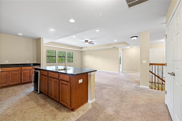 kitchen featuring a sink, a ceiling fan, brown cabinets, and visible vents