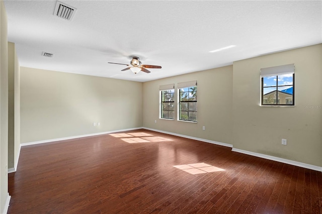 unfurnished room with visible vents, a ceiling fan, baseboards, and wood finished floors