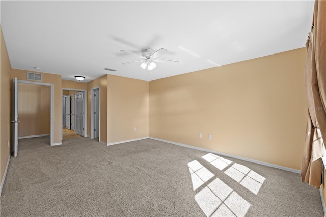carpeted empty room featuring baseboards, a ceiling fan, and visible vents