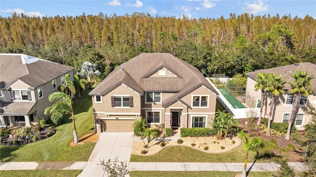 11818 Gilmerton Dr, Riverview, FL 33579 - craftsman-style home with an attached garage, a front lawn, stucco siding, concrete driveway, and a forest view