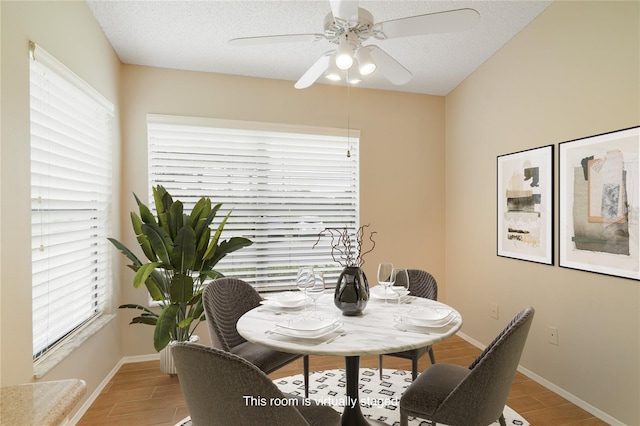 dining room featuring a ceiling fan, baseboards, and light wood-style flooring