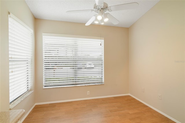 unfurnished room featuring a healthy amount of sunlight, light wood-style floors, and a ceiling fan