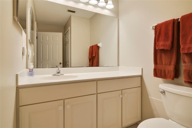 bathroom with visible vents, toilet, and vanity