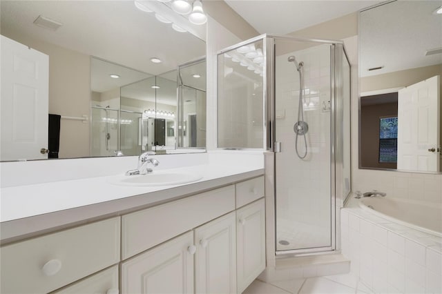 full bathroom with vanity, a bath, and a stall shower