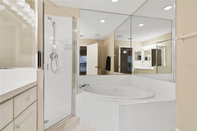 bathroom with vanity, a bath, a stall shower, and recessed lighting