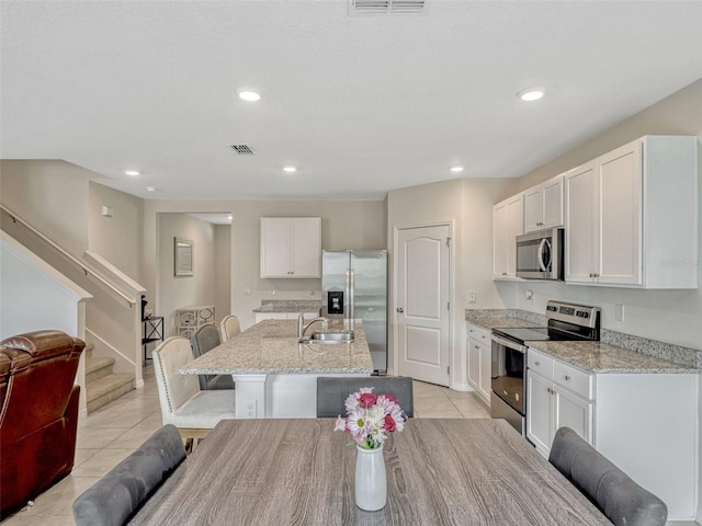 3033 Beau Loop, Tavares, FL 32778 - kitchen with a sink, light tile patterned floors, a breakfast bar area, and stainless steel appliances