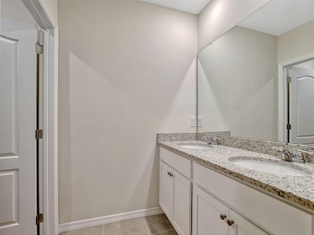 3033 Beau Loop, Tavares, FL 32778 - bathroom with baseboards, a sink, tile patterned flooring, and double vanity
