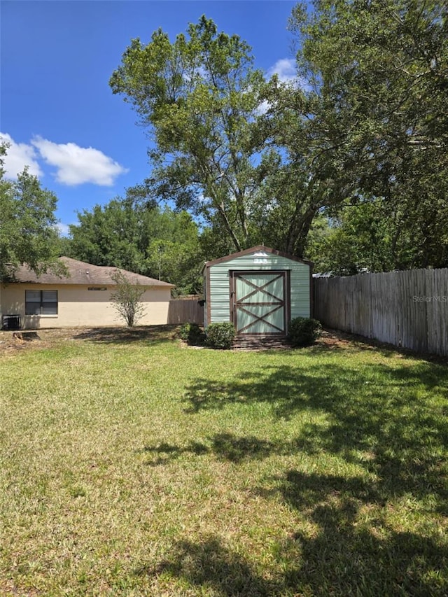 view of yard with a storage unit, a fenced backyard, and an outdoor structure