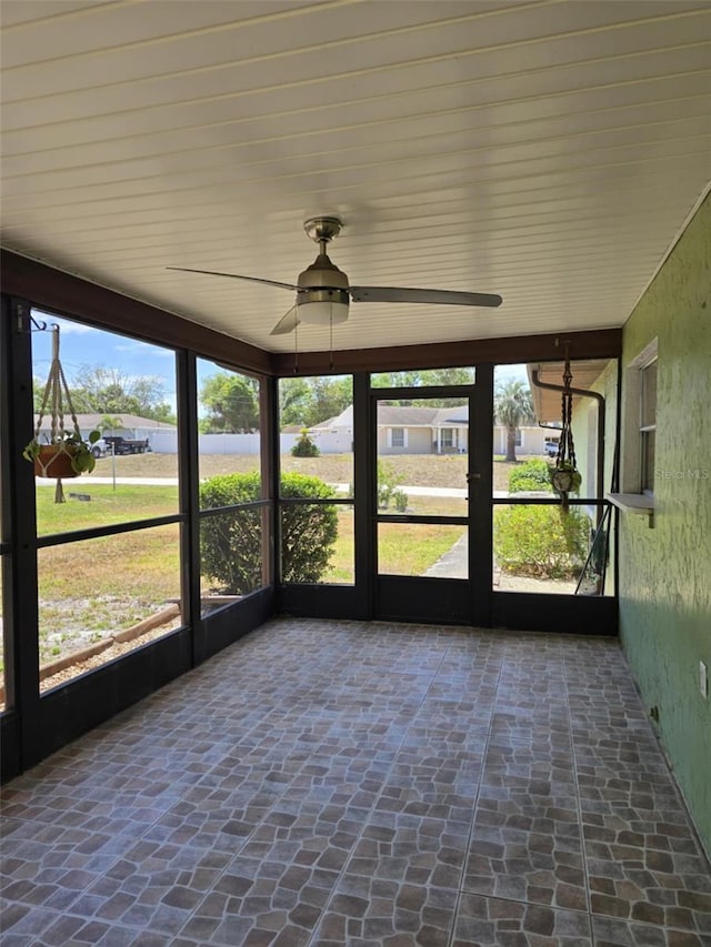 unfurnished sunroom with a ceiling fan