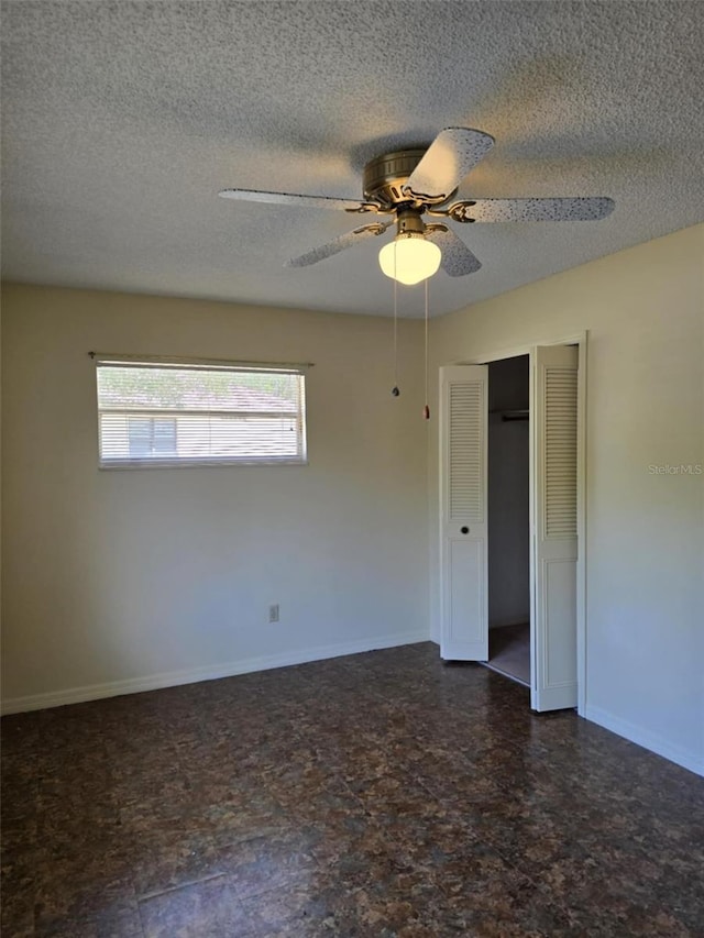 unfurnished room featuring a ceiling fan, a textured ceiling, and baseboards