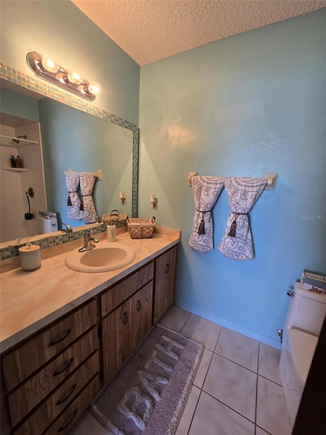 bathroom with vanity, tile patterned flooring, toilet, and a textured ceiling