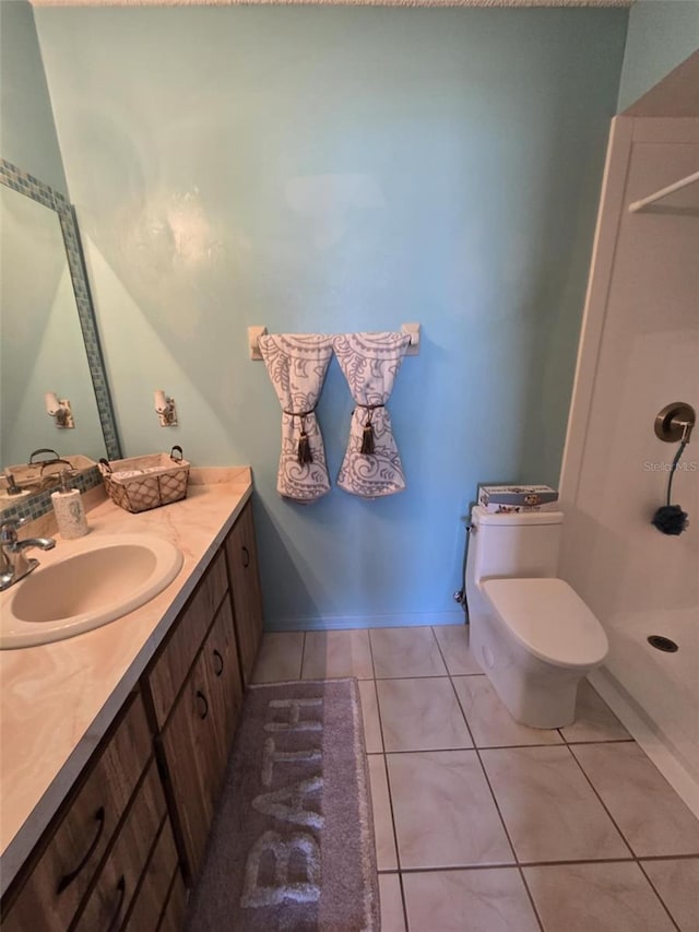 full bathroom with tile patterned flooring, walk in shower, vanity, baseboards, and toilet