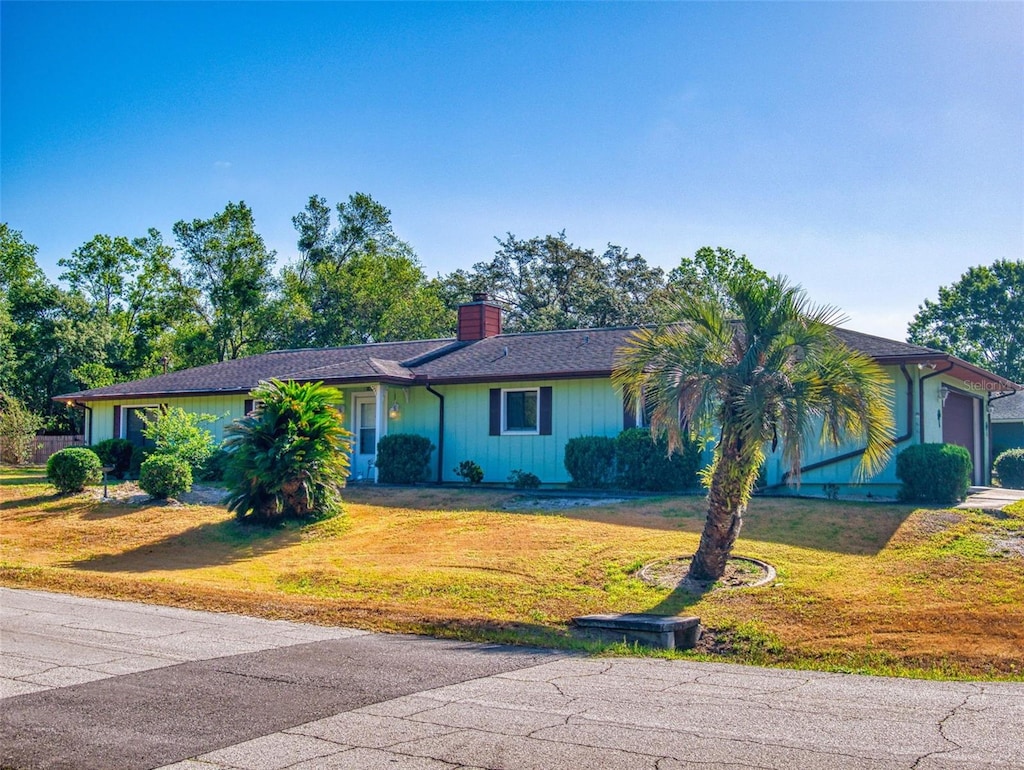 1872 N Akron Dr, Deltona, FL 32738 - ranch-style home featuring a chimney, a front yard, and an attached garage